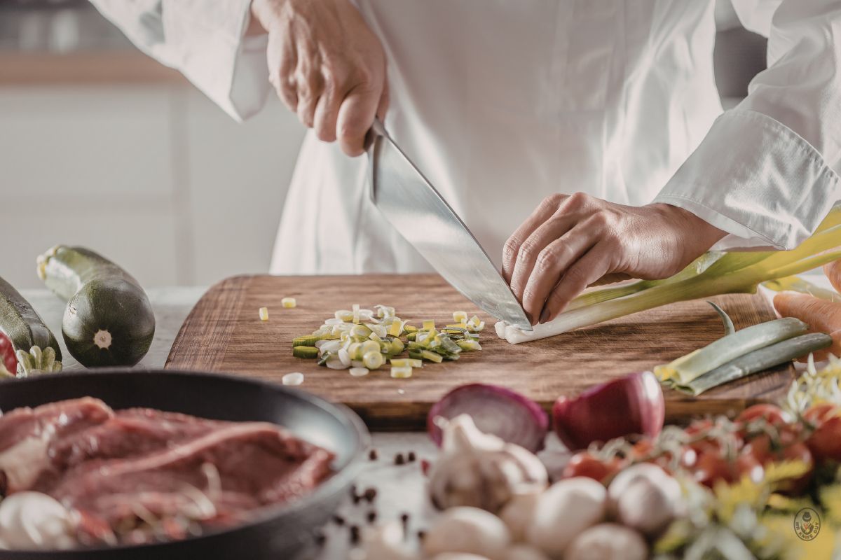 Chef chopping leeks with a sharp knife