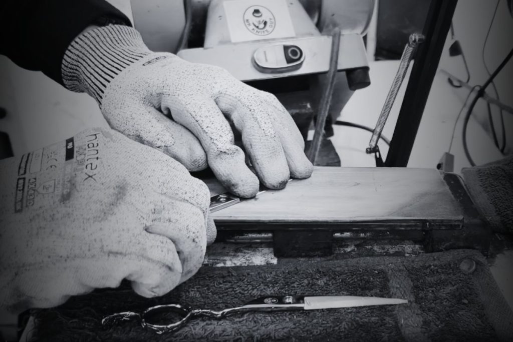 Haidressing scissors being sharpened by hand